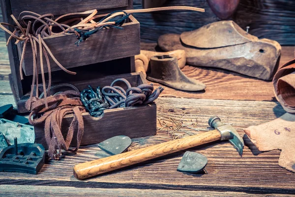 Vintage skomakare arbetsplats med skor, skosnören och verktyg — Stockfoto