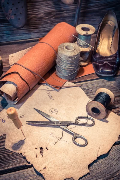 Vintage schoenmaker werkplek met hulpprogramma's, schoenen en leder — Stockfoto