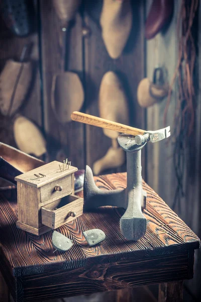 Old shoemaker workplace with tools, shoes and leather