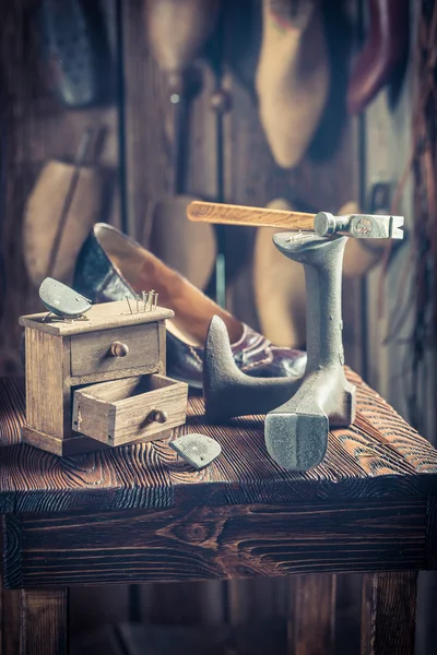 Oficina de sapateira velha com ferramentas, sapatos e cadarços — Fotografia de Stock