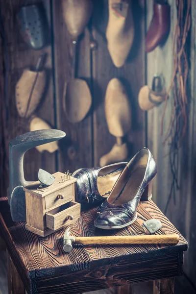 Oficina de sapateira velha com ferramentas, sapatos e couro — Fotografia de Stock