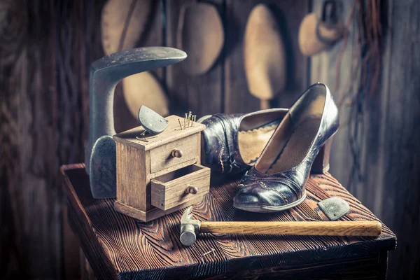 Oficina de sapateira velha com ferramentas, couro e sapatos — Fotografia de Stock