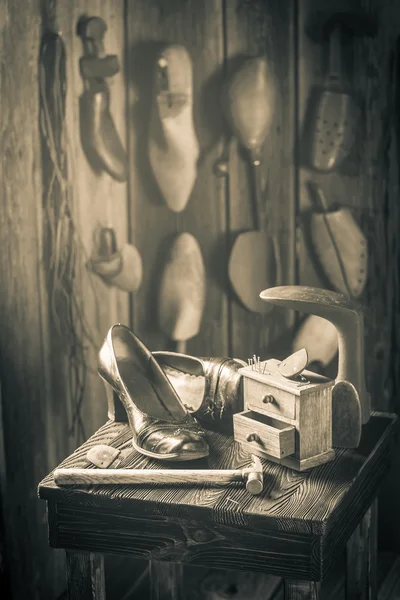 Vecchio posto di lavoro calzolaio con spazzola e scarpe — Foto Stock