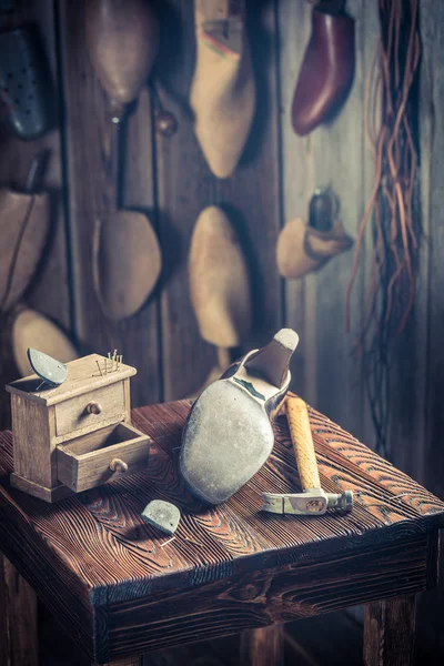 Aged shoemaker workplace with brush and shoes — Stock Photo, Image