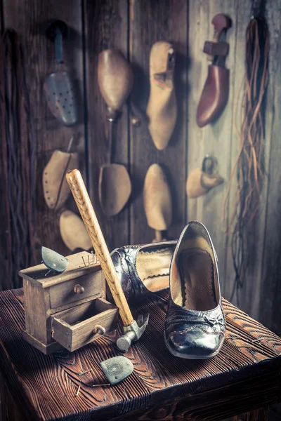 Oficina de sapateira envelhecida com ferramentas, sapatos e cadarços — Fotografia de Stock