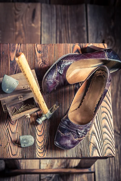 Leeftijd schoenmaker workshop met borstel en schoenen — Stockfoto