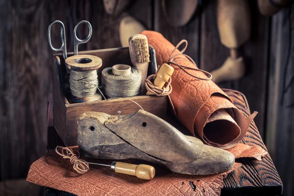 Kleine Schuhmacherwerkstatt mit Schuhen, Schnürsenkeln und Werkzeug — Stockfoto