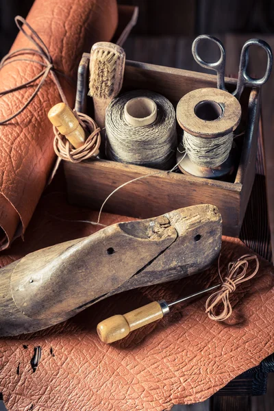 Pequena oficina de sapateiro com escova e sapatos — Fotografia de Stock