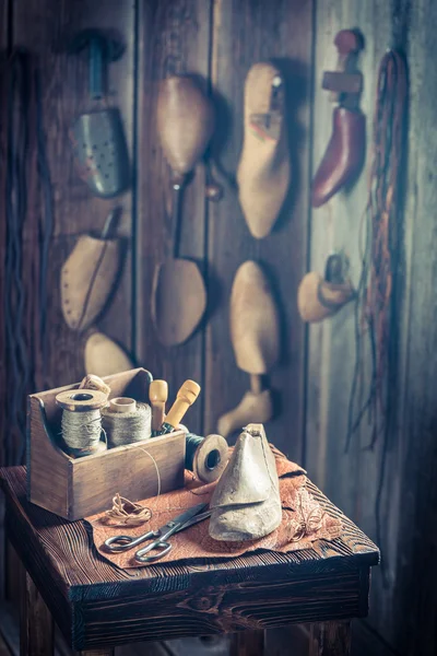 Pequeño lugar de trabajo zapatero con zapatos, cordones y herramientas — Foto de Stock