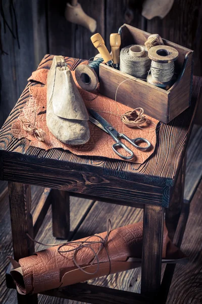 Pequena oficina de sapatilhas com ferramentas, sapatos e cadarços — Fotografia de Stock