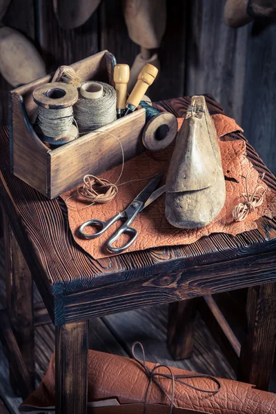 Petit atelier de cordonnier avec chaussures, lacets et outils — Photo