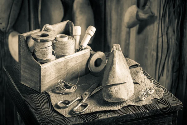 Kleine schoenmaker werkplek met hulpprogramma's, schoenen en leder — Stockfoto