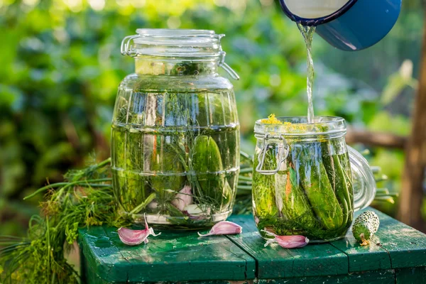 Pouring water homemade pickled cucumbers — Stock Photo, Image