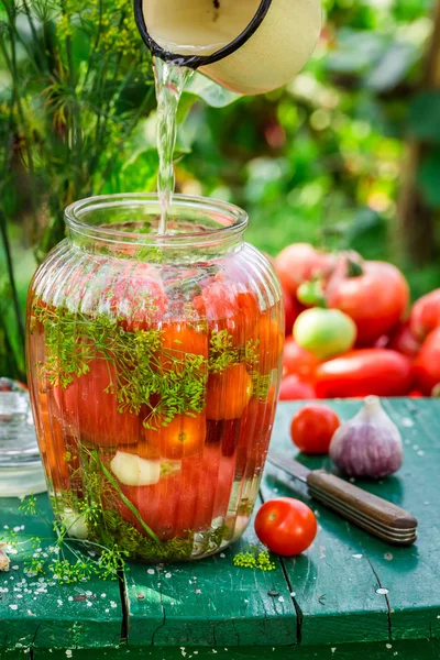 Despejar água em tomates em conserva — Fotografia de Stock