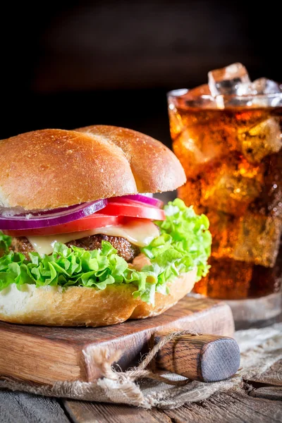 Close-up van smakelijke hamburger en koude dranken — Stockfoto