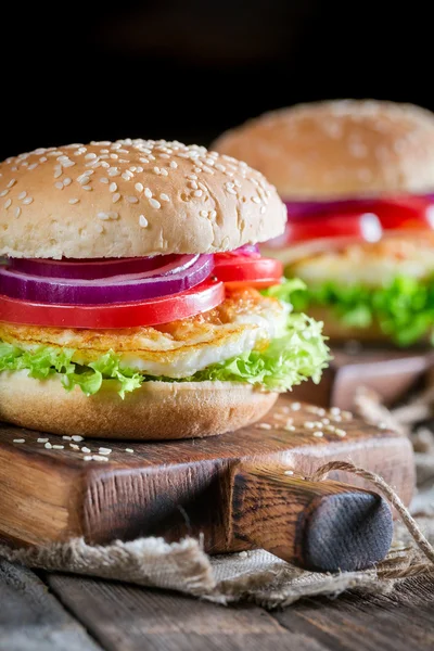 Closeup of two burgers with vegetables and fried egg — Stock Photo, Image