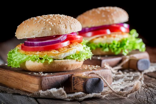 Closeup of fresh burger with fried egg and vegetables — Stock Photo, Image