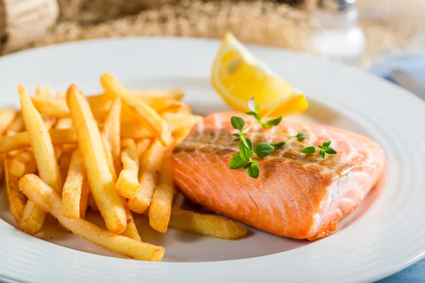 Close-up van heerlijke zalm met chips met citroen — Stockfoto