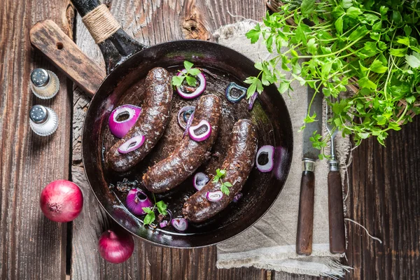 Hot black pudding with onion and parsley — Stock Photo, Image