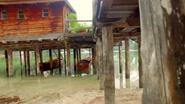 Cabaña de madera en un lago de montaña Pragser Wildsee en los Alpes en Italia — Vídeo de stock