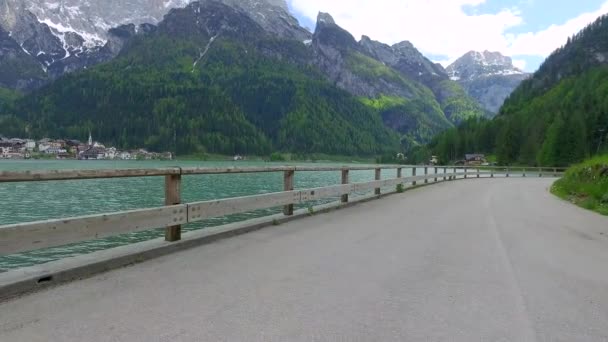 Den lilla staden Alleghe på sjön i Dolomiterna vid foten av bergen — Stockvideo