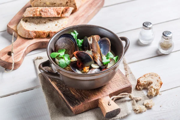 Tasty mussels with garlic and red peppers served with bread — Stock Photo, Image