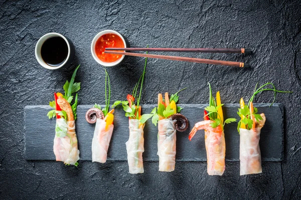 Spring rolls served with soy sauce on a stone plate — Stock Photo, Image