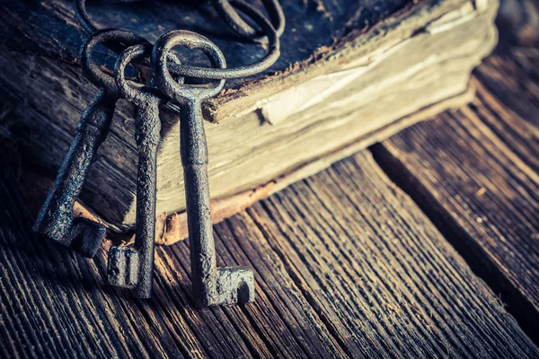 Vintage sleutels en boeken over oude houten tafel — Stockfoto