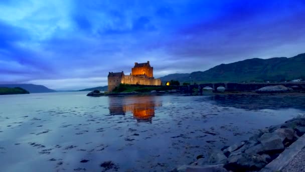 Hermosa puesta de sol en el iluminado Castillo de Eilean Donan sobre el lago en Escocia — Vídeos de Stock