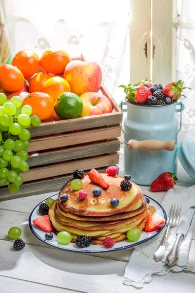 Panquecas saborosas com frutas e xarope de bordo — Fotografia de Stock