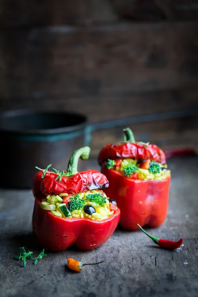 Hot peppers stuffed with rice and vegetables on dark background