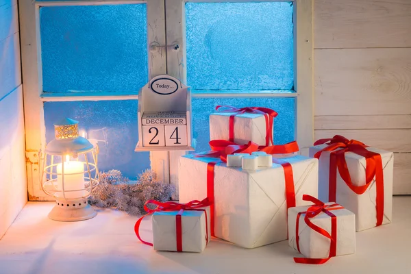 Regalos para Navidad con ventana azul congelada y luz de las velas —  Fotos de Stock