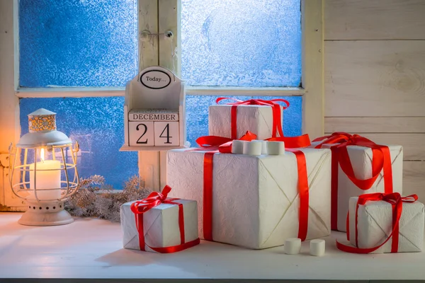 Δώρα για τα Χριστούγεννα με μια παγωμένη μπλε παράθυρο και λευκό τραπέζι — Φωτογραφία Αρχείου