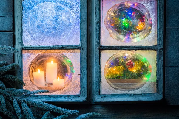 Hermosas velas encendidas para Navidad en ventana congelada — Foto de Stock