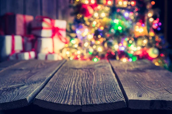 Fondo de Navidad con mesa de madera vieja, bokeh luz y regalos — Foto de Stock