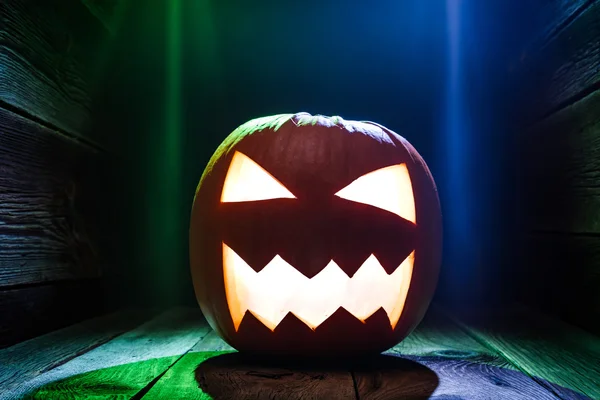 Glühende Kürbisse zu Halloween auf Holztisch — Stockfoto
