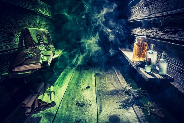 Heks hut met drankjes, rollen, boeken en blauw, groen rook met kopie ruimte voor Halloween — Stockfoto