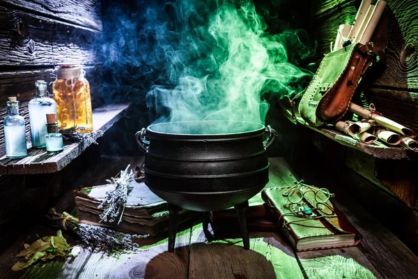 Witcher cauldron with blue potions and books for Halloween — Stock Photo, Image