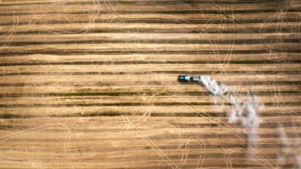 Blick von oben auf einen Traktor, der im Herbst ein Feld pflügt — Stockvideo