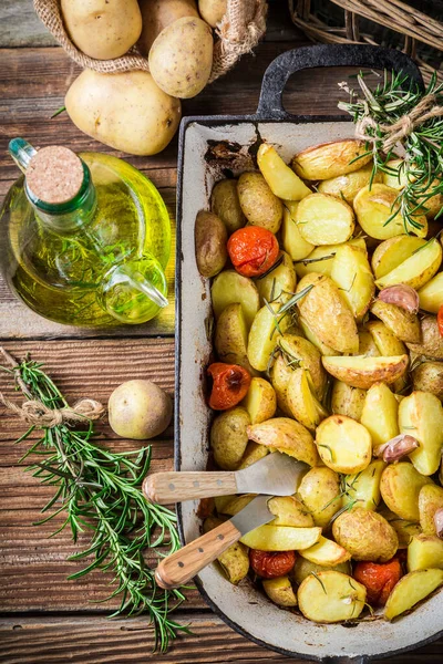 Gebackene Kartoffeln Mit Kirschtomaten Knoblauch Und Rosmarin Auf Holztisch — Stockfoto