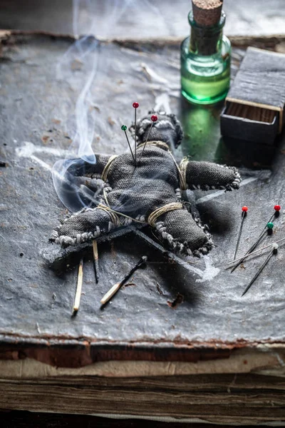 ブードゥー教の人形毒火傷針で刺された古い本 — ストック写真