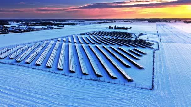 Granja fotovoltaica congelada en invierno al atardecer, vista aérea — Vídeos de Stock