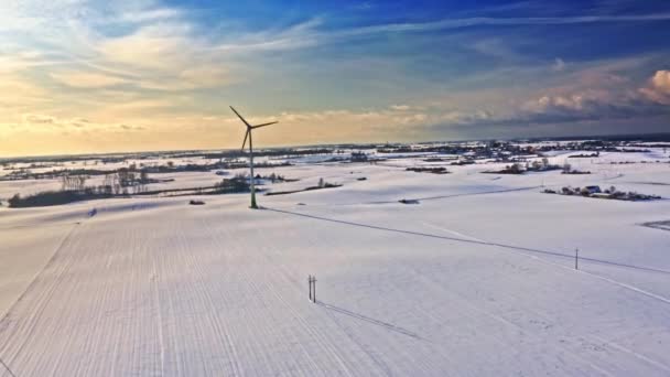 Turbina wiatrowa na zaśnieżonym polu. Zimowa alternatywna energia. Widok z lotu ptaka — Wideo stockowe