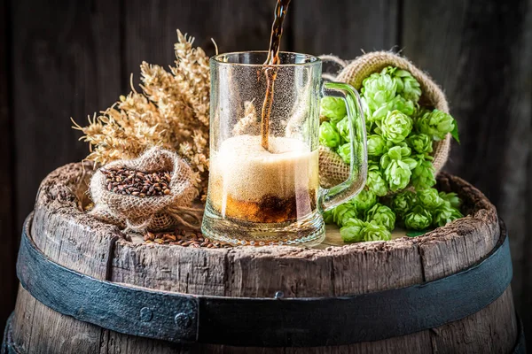 濃いビールを泡の大きいガラスに入れる 醸造業 木製の樽生ビール — ストック写真