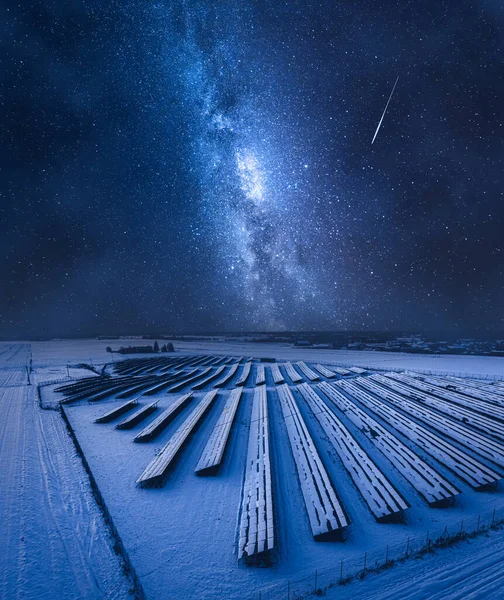 Milky way over photovoltaic farm at night. Alternative energy in winter, Poland. Pure energy from sun.