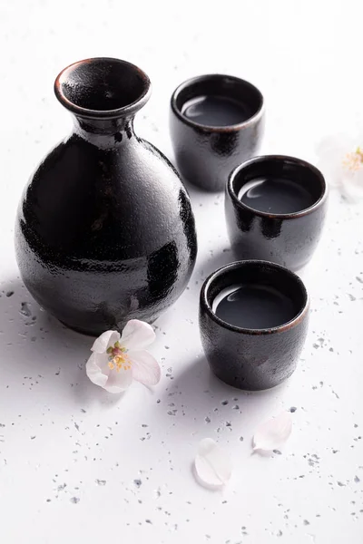 黒陶器の日本酒 酒を飲む日本の習慣 白い石の上に黒い陶器 — ストック写真