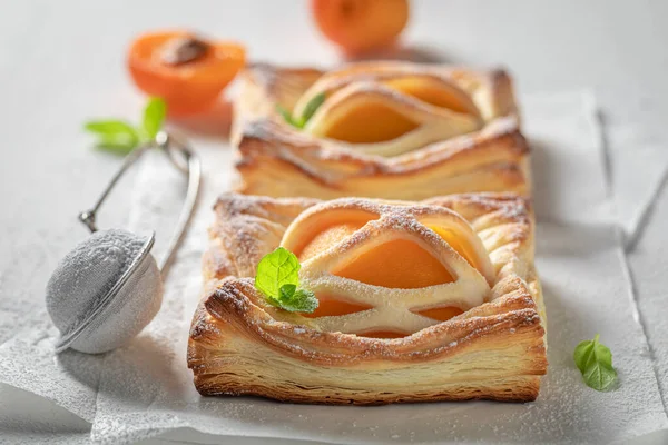 Homemade puff pastry with sugar and peaches. French juicy dessert. French cuisine.
