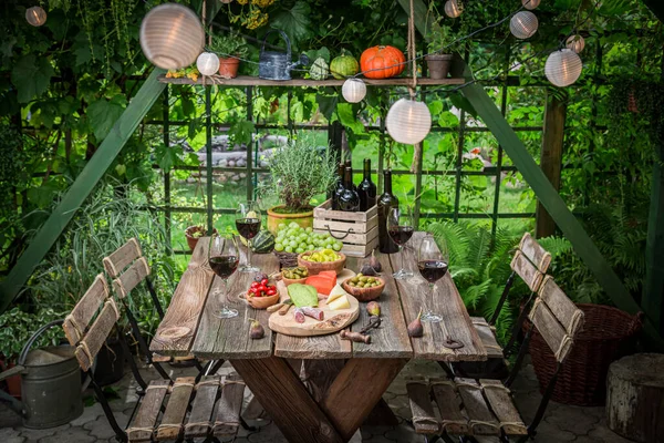 Garden table with cheese and wine Evening garden meeting. Summer evening in the garden with food and wine.