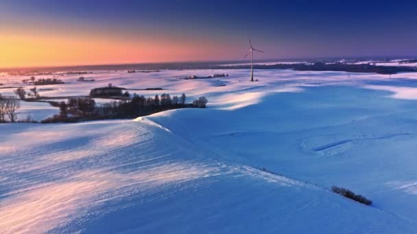 Champ neigeux et éolienne. Vue aérienne de la nature hivernale — Video