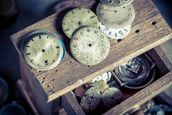 Vintage watchmaker's workplace with repaired clocks. Forgotten watchmaker's workplace. Forgotten craft profession.